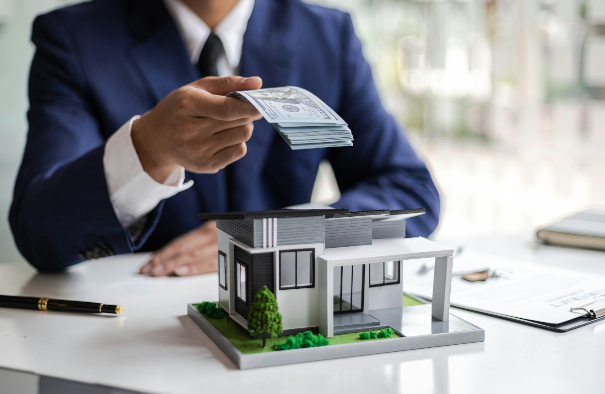 Real estate businessman giving money for buying a house.